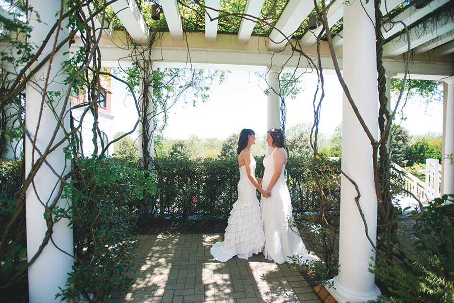 Lin and Caryanne, newly married, share a quiet moment under the arbor in the Cloister Garden at O.Henry Hotel