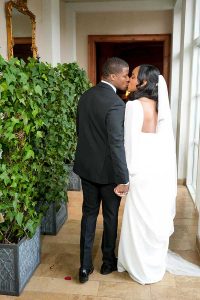 The bride and groom walk down the mirrored hallway.