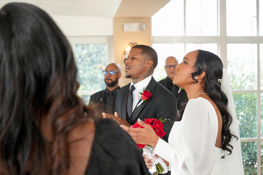 Latisha and Ronald | Still Shots Photography The couple holds hands and worships during the wedding ceremony.