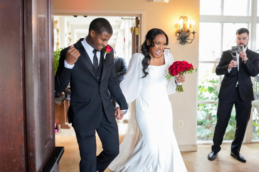 Latisha and Ronald enter their reception enthusiastically as they are greeted by cheering guests